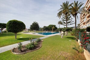 A landscaped area with a swimming pool, palm trees, and a pathway. - Apartment 'Vistas Al Mar Torremolinos' with Sea View, Wi-Fi, and Air Conditioning (Torremolinos)