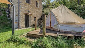 Un bâtiment en pierre avec un escalier en bois menant à une tente.