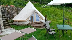 Ein Zelt mit Tisch, Stühlen und einer Rasenfläche.