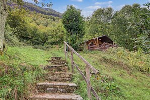 Un escalier en bois rustique menant à un chalet situé dans une zone boisée.