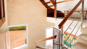 A modern interior with a staircase, a view of a tiled patio, and a painting on the wall. - Villa 'Gran Cerca De Puerto Banús' with Mountain Views, Wi-Fi, and Air Conditioning (Marbella)