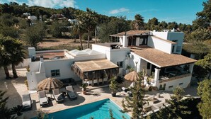 Una villa moderna con piscina, mobiliario de exterior y vistas del paisaje circundante.