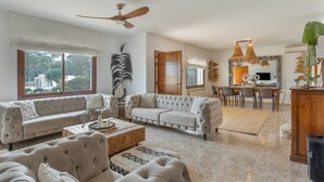 A spacious living area with a sofa, coffee table, and a dining area with chairs and a table. - Villa "Amigo Near Las Dalias - Nice" (Illes Balears)