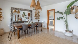 A dining area with a large mirror, wicker hanging lights, and a potted plant. - Villa "Amigo Near Las Dalias - Nice" (Illes Balears)