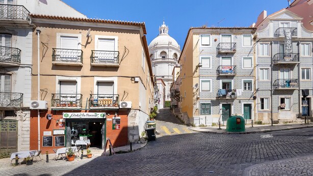 A street with buildings, a dome, and a sign for 'Gruta de Paraíso.'
