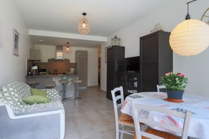 Una cocina moderna con comedor, que incluye un sofá, sillas y una mesa con una planta en maceta.
