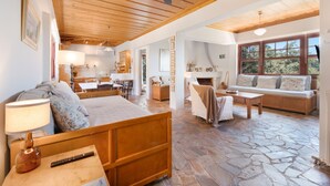 A spacious living area with a stone floor, wooden furniture, and a ceiling fan. - Apartment 'Katouna 4-bdrms Bright Home' with Sea View (Katouna)