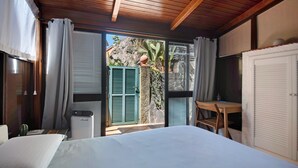 A bedroom with a bed, a desk, a chair, and a window with curtains. - 'Terrazza Sivori' Apartment with Mountain View, Wi-Fi and Air Conditioning (bonassola)