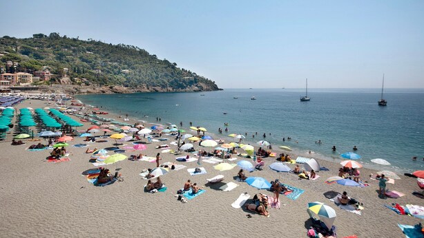A beach with numerous colorful umbrellas and people sunbathing. - 'Terrazza Sivori' Apartment with Mountain View, Wi-Fi and Air Conditioning (bonassola)