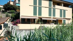A multi-story building with green shutters, a visible balcony, and a staircase leading to an upper floor. - 'Terrazza Sivori' Apartment with Mountain View, Wi-Fi and Air Conditioning (bonassola)