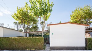 A modern building with a covered outdoor area, a white exterior, and a green 'F' marking. - Bungalow 'F' with Private Pool, Private Terrace and Wi-Fi (Pontevedra)