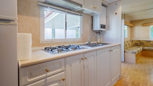 A kitchen with a gas stove, sink, and window. - Bungalow 'F' with Private Pool, Private Terrace and Wi-Fi (Pontevedra)