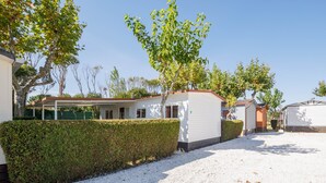 A residential area with a white building, a covered porch, and a hedge. - Bungalow 'F' with Private Pool, Private Terrace and Wi-Fi (Pontevedra)