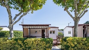 A row of mobile homes with a gravel driveway and a hedge in the foreground. - Bungalow 'B' with Private Pool, Private Terrace and Wi-Fi (Pontevedra)