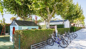 A children's play area with a small building labeled 'PARQUE INFANTIL,' bicycles parked by a hedge, and a gravel path. - Bungalow 'B' with Private Pool, Private Terrace and Wi-Fi (Pontevedra)