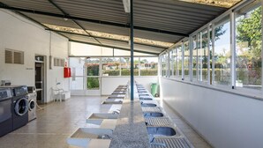 A public restroom with multiple sinks, a washing machine, and a trash bin. - Bungalow 'B' with Private Pool, Private Terrace and Wi-Fi (Pontevedra)