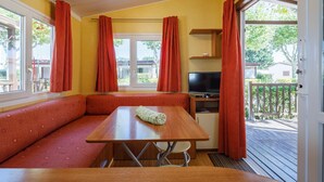 A room with a wooden table, a TV, and a bench. - Bungalow 'D' with Private Pool, Private Terrace and Wi-Fi (Pontevedra)