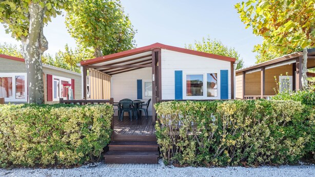 A mobile home with a covered porch, a table with chairs, and a gravel driveway. - Bungalow 'D' with Private Pool, Private Terrace and Wi-Fi (Pontevedra)