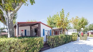 A row of single-story mobile homes with a covered porch, surrounded by well-maintained hedges and a clear sky. - Bungalow 'D' with Private Pool, Private Terrace and Wi-Fi (Pontevedra)