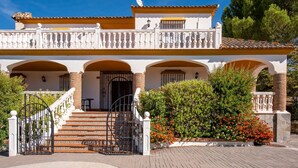 A two-story building with a balcony, a staircase, and a gate.
