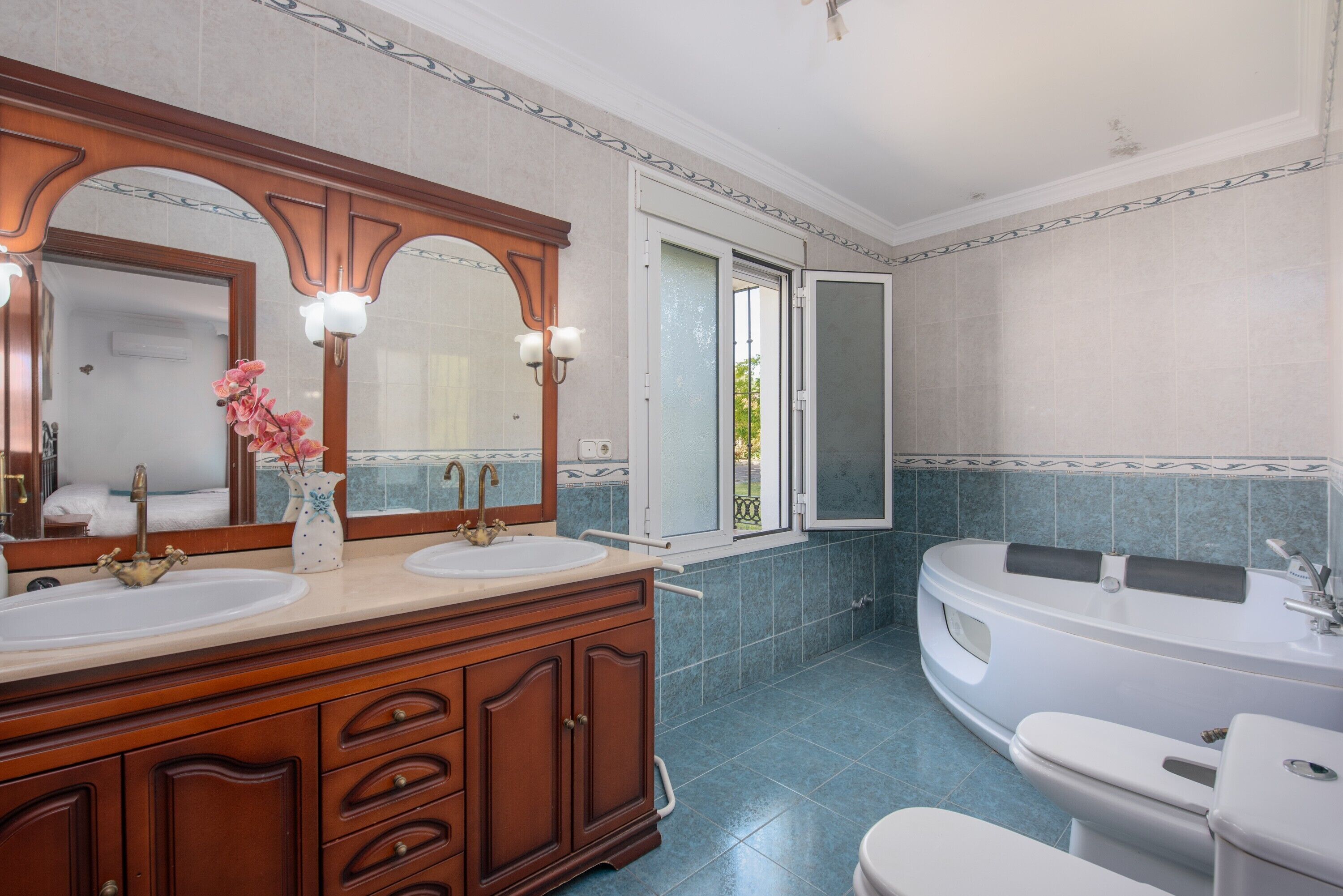 Une salle de bain avec deux lavabos, une baignoire et des toilettes.