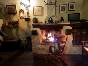 A cozy room with a fireplace, wooden furniture, and vintage decor.