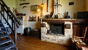A rustic room with a wooden staircase, a fireplace, and various antique items on the walls. - Apartment 'Col Di Metino' with Mountain View, Private Garden and Wi-Fi (Gualdo Tadino)