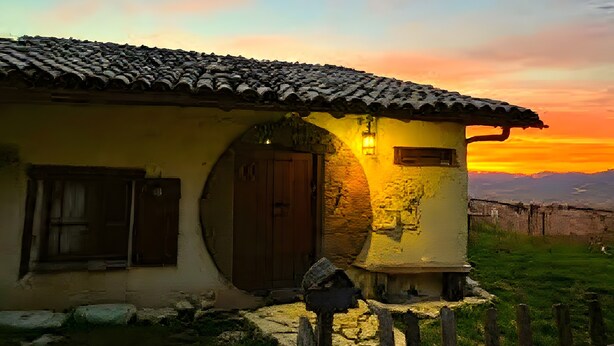 A rustic house with a tiled roof, a wooden door, and a small window. - Apartment 'Col Di Metino' with Mountain View, Private Garden and Wi-Fi (Gualdo Tadino)