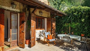 A rustic wooden house with a patio, a guitar, and a table with chairs. - Apartment 'Col Di Metino' with Mountain View, Private Garden and Wi-Fi (Gualdo Tadino)