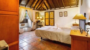 Ein Schlafzimmer mit Holzboden, einem Bett, einem Schreibtisch und einem Stuhl.