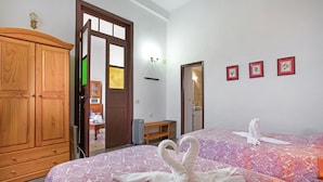 Un dormitorio con cama, armario de madera y puerta que da a otra habitación.