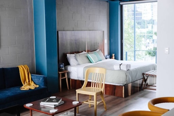 Relax in a stylish room with a large bed, city views, and a comfortable seating area.