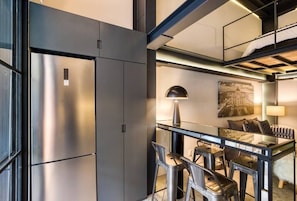 Relax in a compact room with a bench, practical workspace, and comfortable seating area.