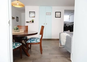 Cozy living space with a dining area and kitchenette, featuring a round table and two chairs.