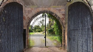 A gated entrance with a brick archway and a metal gate. - Caverswall Castle - Grade 1 Listed Historic Castle - Inquire for best quote now (Caverswall)