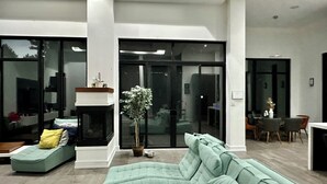 A modern living room with a green sofa, a small table, and a fireplace.
