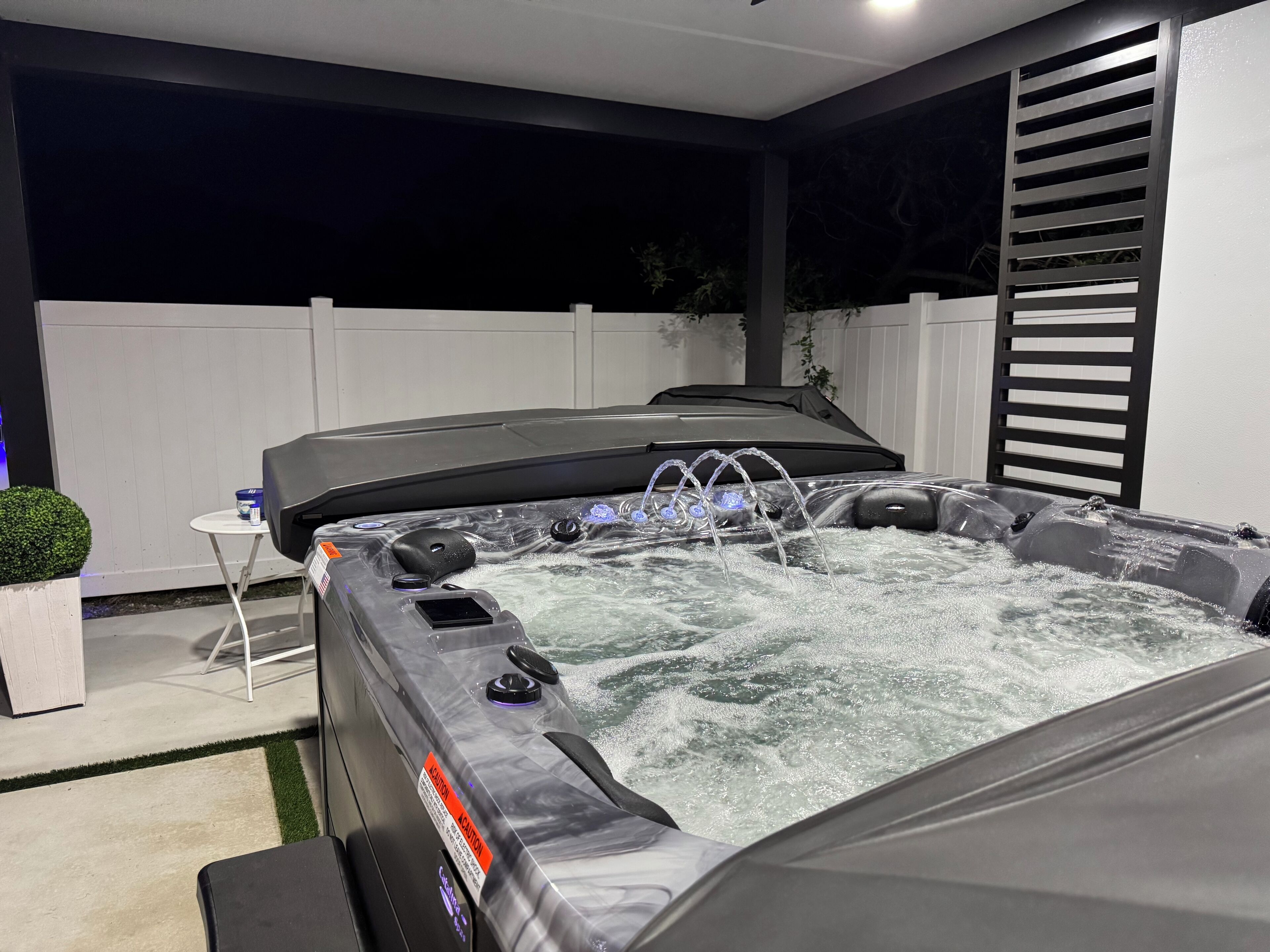 Un jacuzzi con múltiples chorros, un panel de control y una etiqueta de precaución.