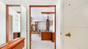 A hallway leading to a dining area with a wooden counter and chairs. - WELCS APARTAMENTO 170 PDA en el puerto (Platja d´Aro)