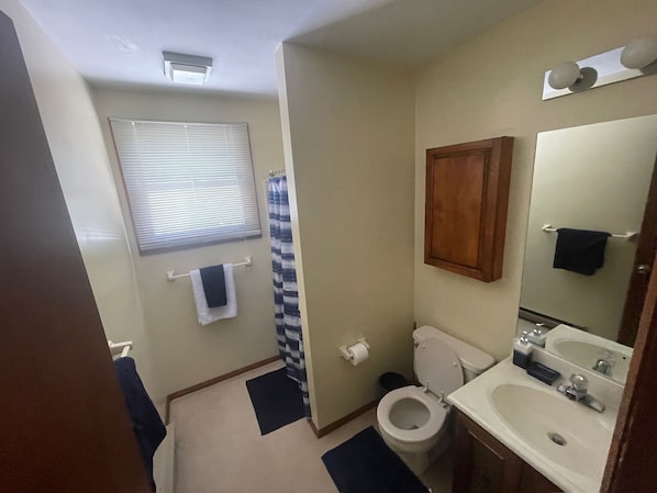 Un baño pequeño con inodoro, lavamanos y espejo.