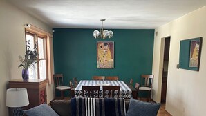 A living room with a sofa, coffee table, dining table, and chairs. - Family Friendly 4 Bedroom House Near Penn State University (State College)