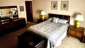 A bedroom with a bed, two bedside tables with lamps, a dresser, and a mirror. - Family Friendly 4 Bedroom House Near Penn State University (State College)