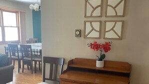 A room with a wooden desk, a chair, and a vase with flowers on the wall. - Family Friendly 4 Bedroom House Near Penn State University (State College)