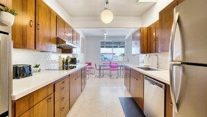 A modern kitchen with wooden cabinets, stainless steel appliances, and a central island with seating.