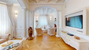 A spacious living room with a large TV, a sofa, two armchairs, and a decorative vase. - Villa Diamante By Bookinggardalake (Salò)