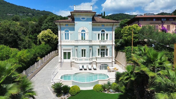 A large, two-story building with a swimming pool, surrounded by lush greenery and hills. - Villa Diamante By Bookinggardalake (Salò)