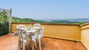 A terrace with a table set for two, overlooking a scenic landscape. - Bellavista by Interhome (Castellina Marittima)