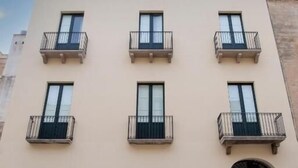 A multi-story building with balconies, large windows, and a flat facade. - 32VENTI (Trapani)