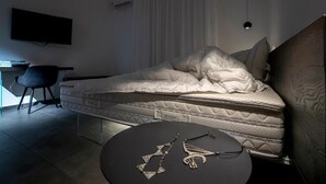 A modern bedroom with a large bed, a desk, and a chair. - 32VENTI (Trapani)