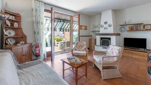 A living room with a sofa, chairs, a television, a fireplace, and a bookshelf. - Appartamento Alessandra: Terrace and Lake View, Laveno Mombello, Italy (Laveno Mombello)