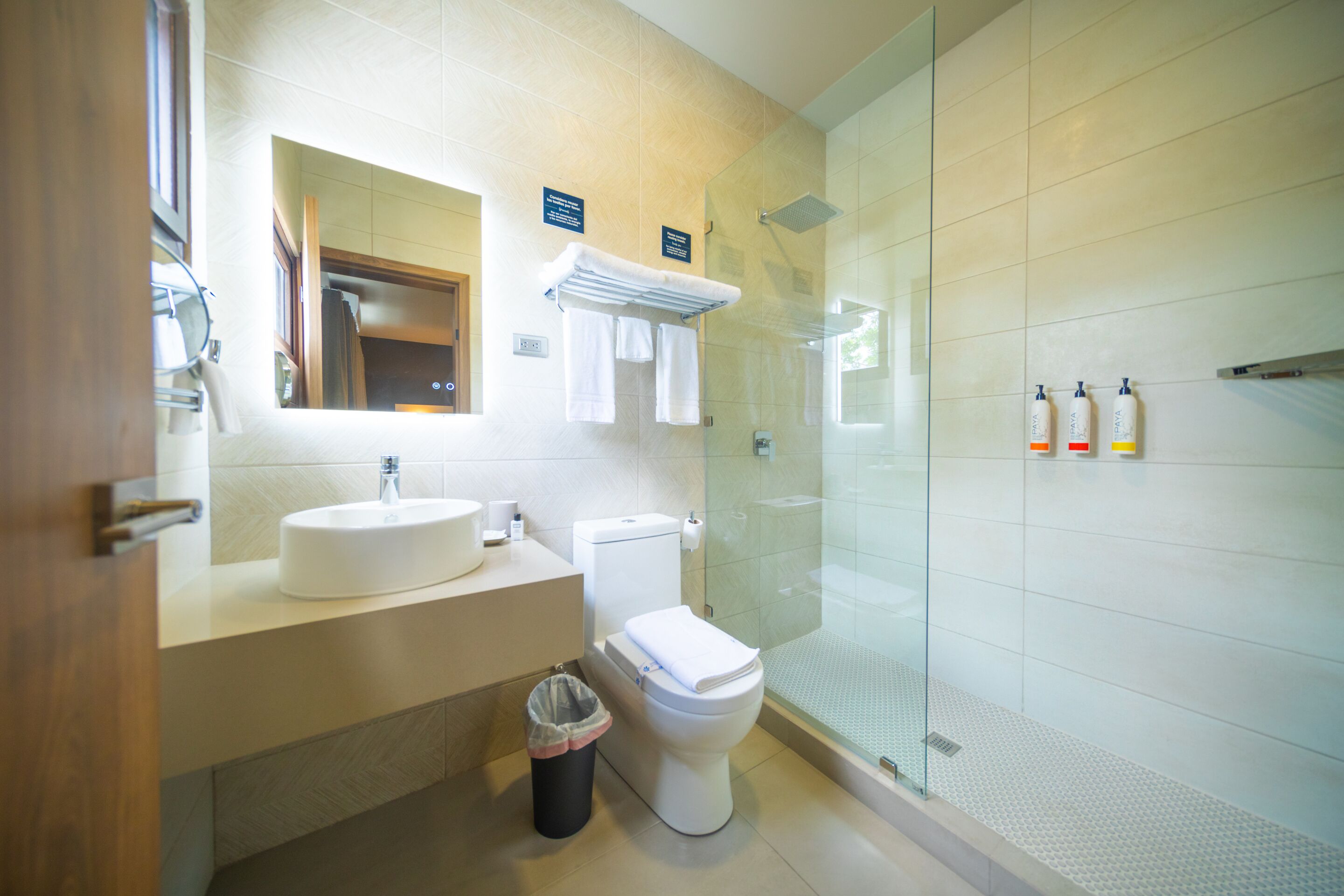 A modern bathroom with a sink, toilet, and glass shower enclosure.